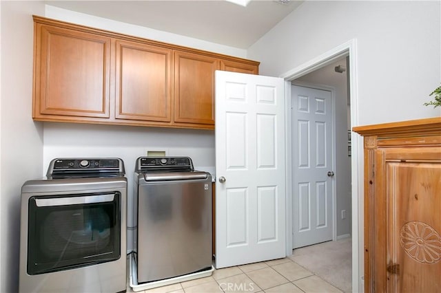 washroom with cabinets, separate washer and dryer, and light tile patterned floors