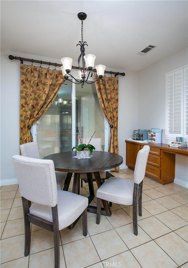 tiled dining room featuring an inviting chandelier