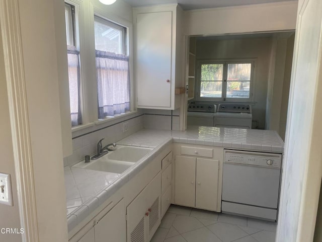 kitchen featuring dishwasher, tile counters, and white cabinets