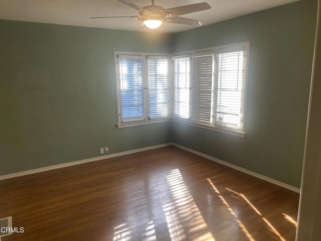 spare room with dark wood-type flooring and ceiling fan