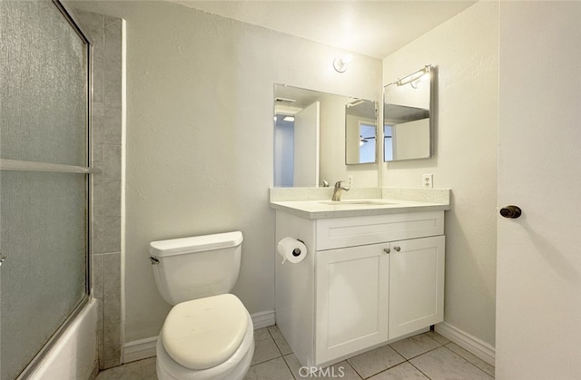 full bathroom featuring enclosed tub / shower combo, vanity, tile patterned floors, and toilet