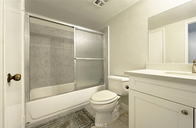 full bathroom featuring tile patterned flooring, vanity, combined bath / shower with glass door, and toilet