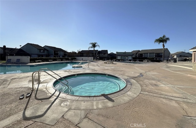 view of pool featuring a community hot tub and a patio area