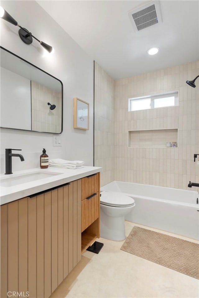 full bathroom with tiled shower / bath combo, vanity, tile patterned floors, and toilet