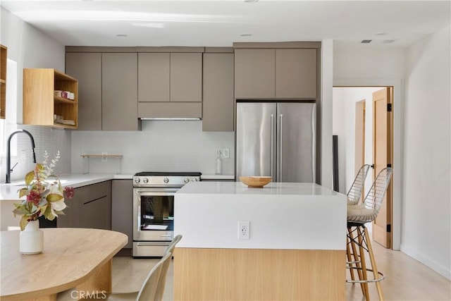 kitchen featuring sink, gray cabinetry, tasteful backsplash, a kitchen island, and stainless steel appliances