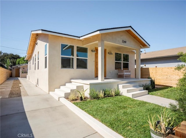 view of front of property with a porch and a front lawn