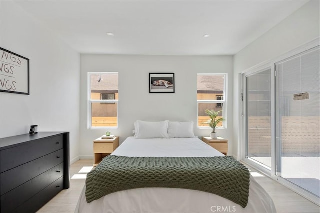 bedroom with access to exterior and light hardwood / wood-style flooring