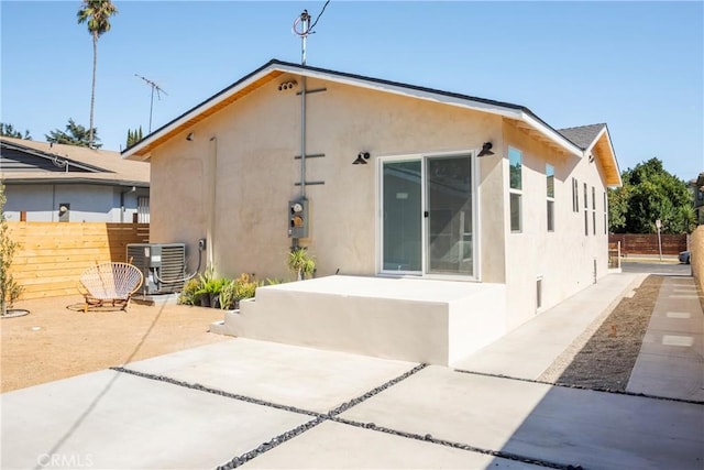 back of property with central AC and a patio area