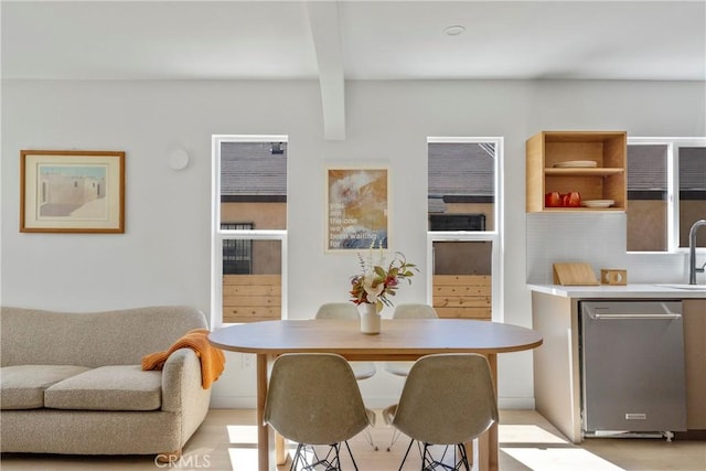 dining area with sink and beam ceiling