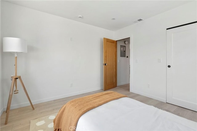 bedroom featuring light hardwood / wood-style flooring and electric panel