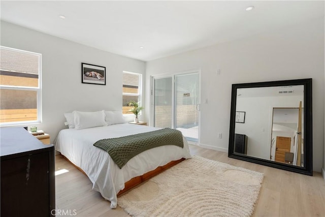 bedroom featuring multiple windows, access to exterior, and light wood-type flooring