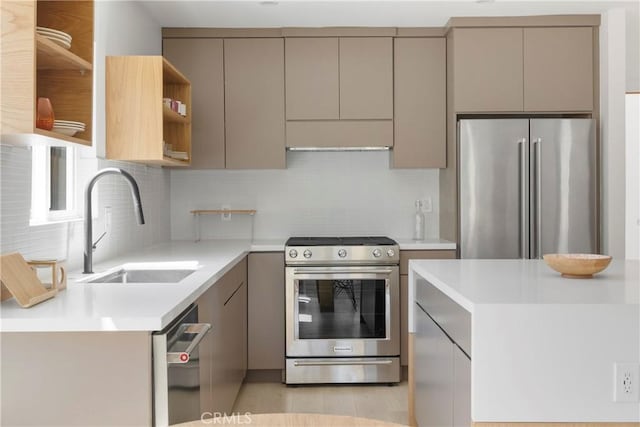 kitchen with gray cabinetry, sink, decorative backsplash, and stainless steel appliances