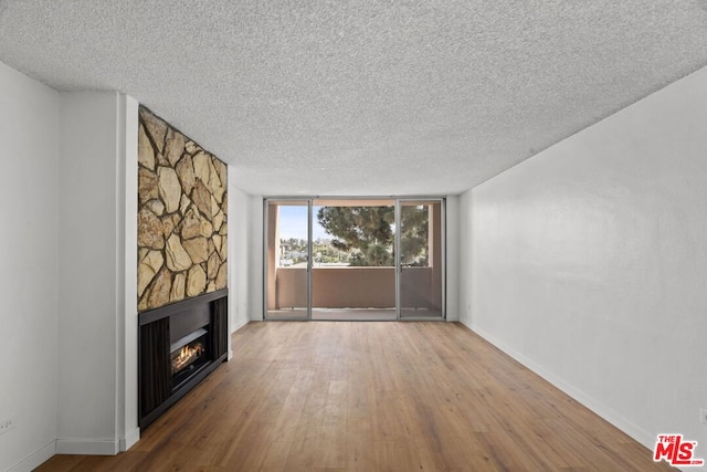 unfurnished living room with a fireplace, hardwood / wood-style floors, and a textured ceiling