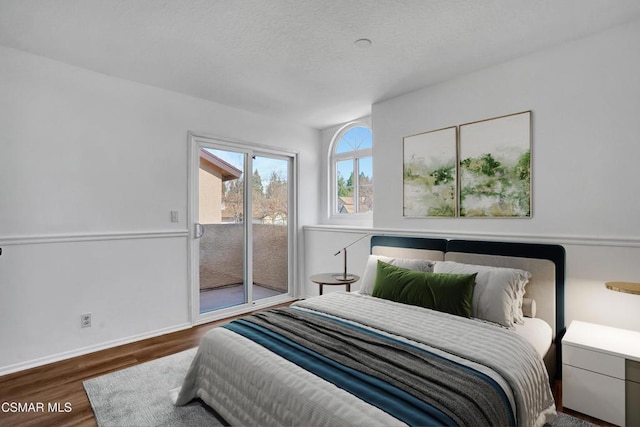 bedroom featuring access to exterior and dark hardwood / wood-style flooring