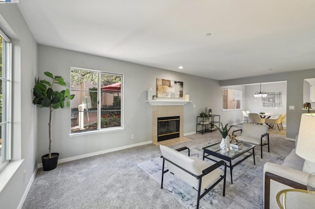 carpeted living room with an inviting chandelier and a tile fireplace