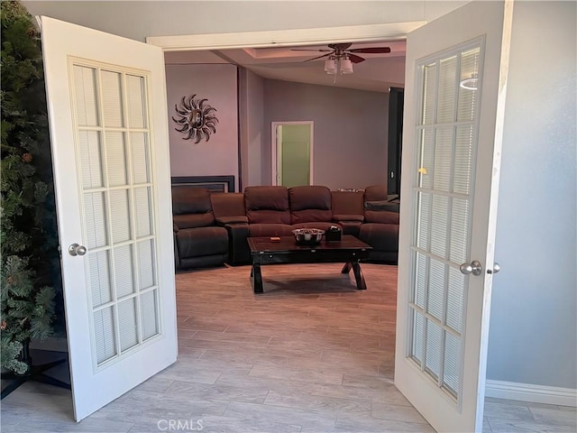 living room featuring ceiling fan, lofted ceiling, and light hardwood / wood-style floors