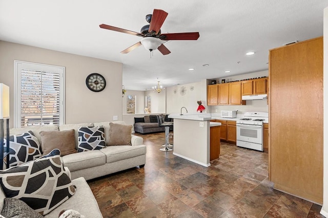 living room with ceiling fan with notable chandelier