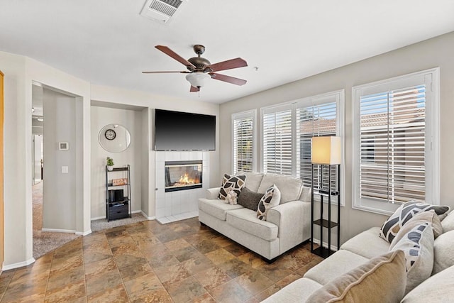 living room with ceiling fan and a fireplace