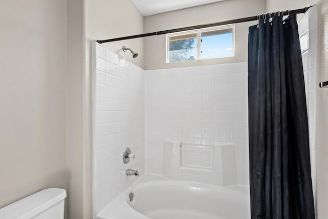 bathroom featuring shower / bath combination with curtain and toilet