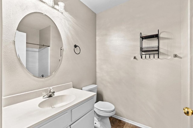 bathroom with walk in shower, vanity, and toilet