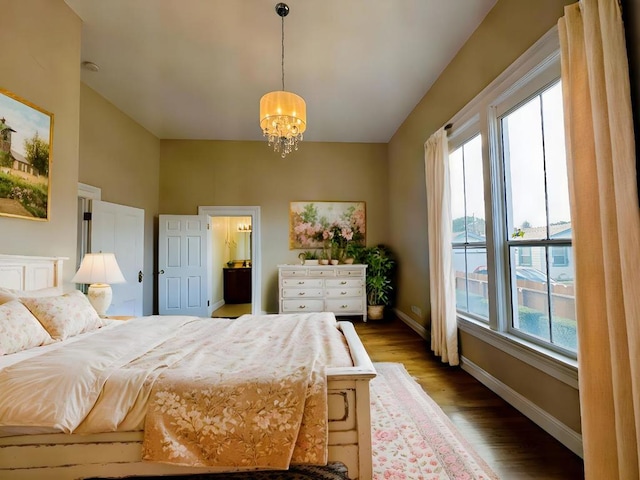 bedroom featuring multiple windows, hardwood / wood-style floors, and a chandelier