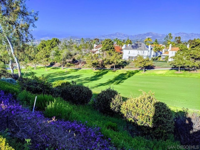 surrounding community featuring a mountain view and a lawn