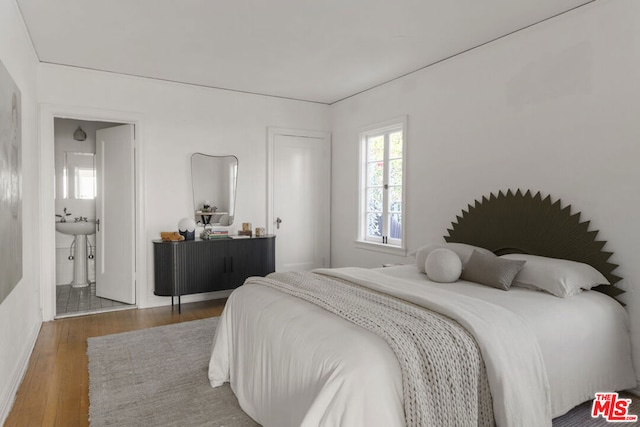 bedroom featuring connected bathroom and hardwood / wood-style floors