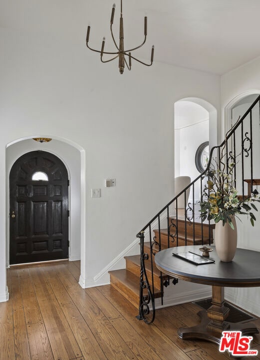 entryway featuring hardwood / wood-style flooring and a chandelier