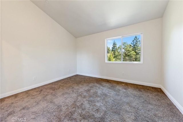 carpeted empty room featuring lofted ceiling