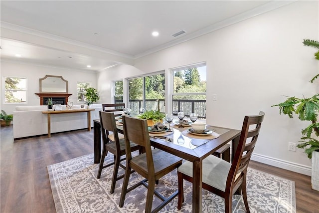 dining space with ornamental molding and dark hardwood / wood-style flooring