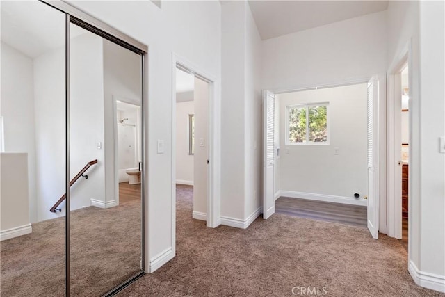 unfurnished bedroom with ensuite bathroom, a closet, and carpet flooring