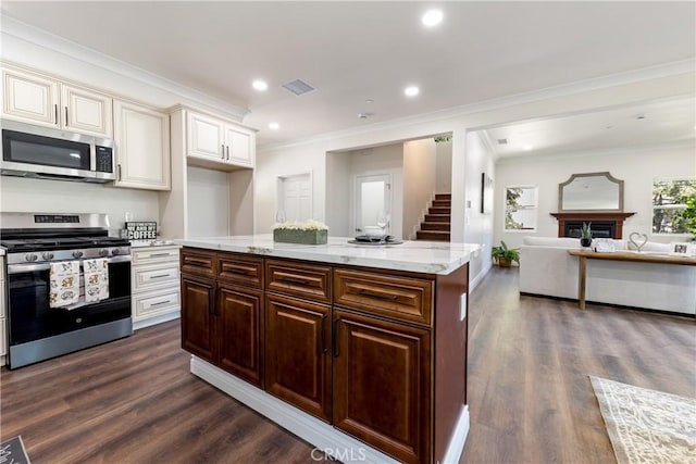 kitchen with stainless steel appliances, ornamental molding, dark hardwood / wood-style floors, and dark brown cabinetry