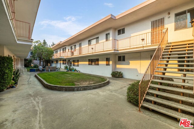 view of home's community featuring a yard and a patio area