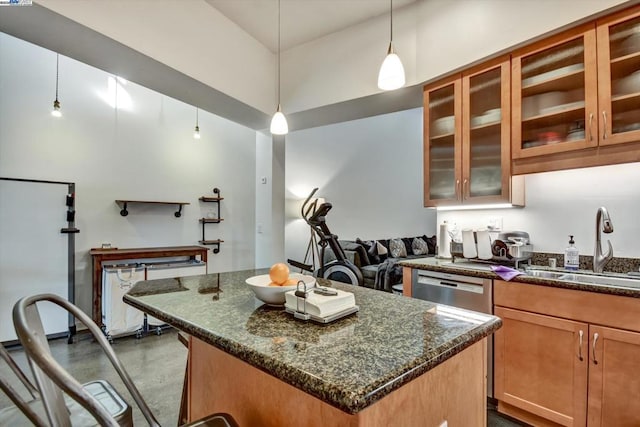 kitchen with concrete flooring, sink, decorative light fixtures, a center island, and dark stone counters