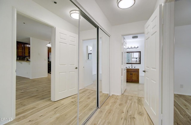 hallway featuring sink and light hardwood / wood-style floors