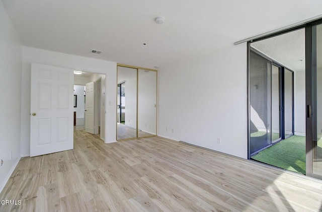 unfurnished room featuring floor to ceiling windows and light hardwood / wood-style floors