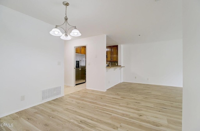 interior space featuring sink, an inviting chandelier, and light hardwood / wood-style flooring