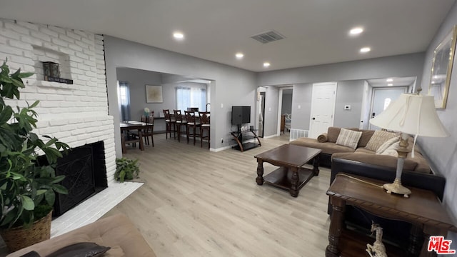 living room featuring a fireplace and light wood-type flooring