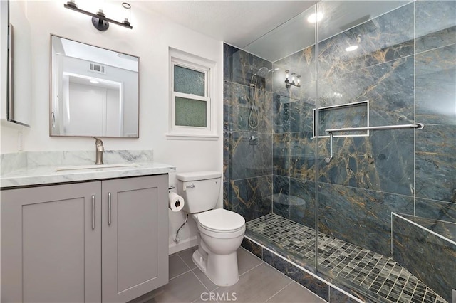 bathroom featuring vanity, toilet, a shower with shower door, and tile patterned flooring