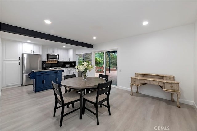 dining room featuring beam ceiling and light hardwood / wood-style floors