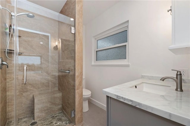 bathroom with vanity, tile patterned flooring, a shower with door, and toilet