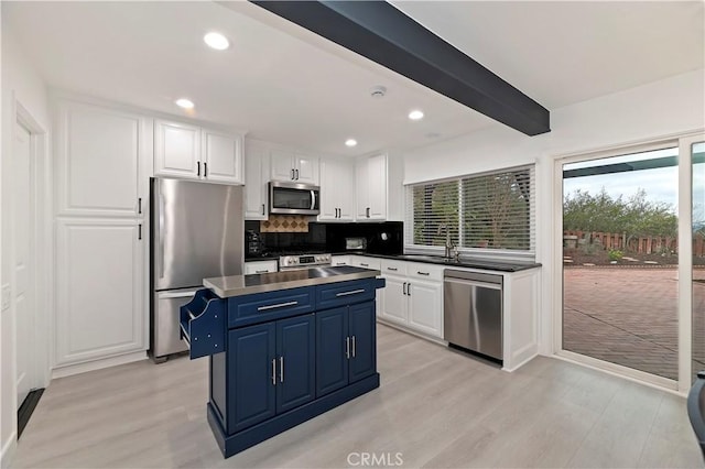 kitchen featuring blue cabinetry, white cabinetry, beam ceiling, stainless steel appliances, and a kitchen island