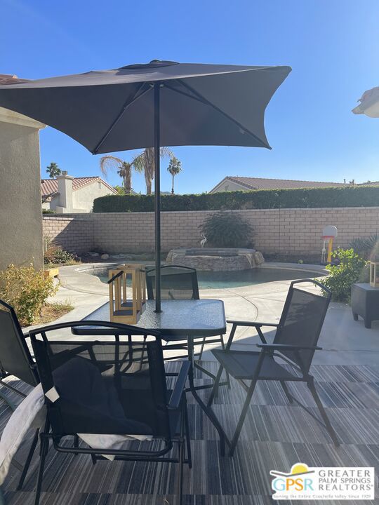 deck with a fenced in pool and a patio