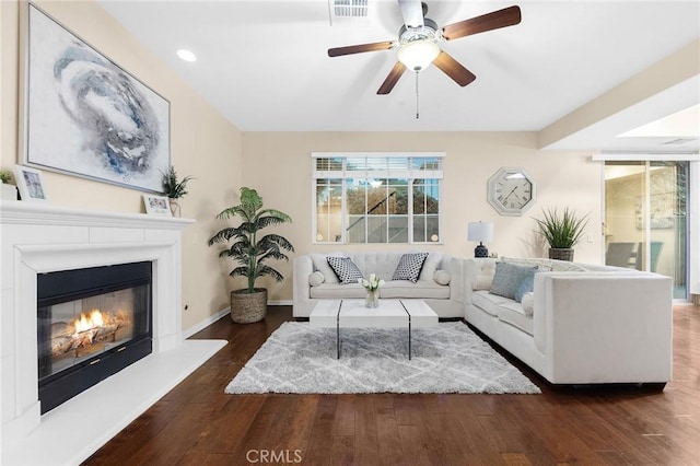 living room with ceiling fan and dark hardwood / wood-style flooring