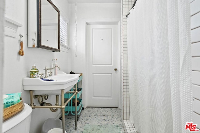 bathroom with toilet and a shower with shower curtain