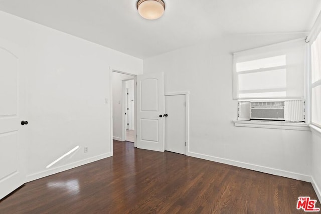 unfurnished room featuring dark hardwood / wood-style flooring, cooling unit, and vaulted ceiling