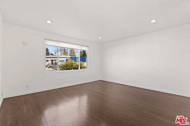 spare room featuring dark wood-type flooring