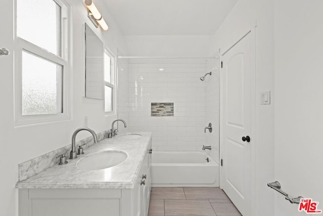 bathroom featuring vanity and tiled shower / bath