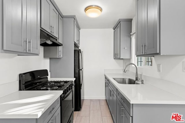 kitchen featuring sink, gray cabinetry, and black appliances