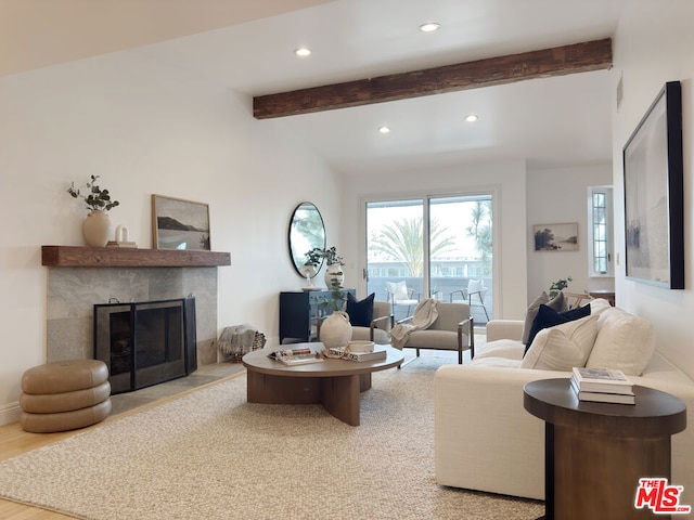 living room featuring light hardwood / wood-style flooring, a fireplace, and lofted ceiling with beams